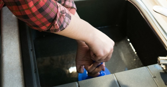 Woman clearing clogged drains with plunger
